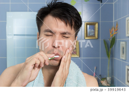 asian man with toothache while brushing teeth 39919643