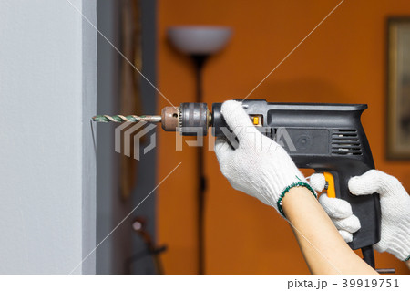 hands holding electric drill in room 39919751