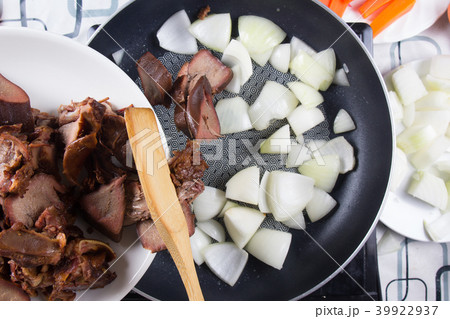 Chef putting slice of pork tongue to pan Chef putting slice of pork tongue to pan 39922937