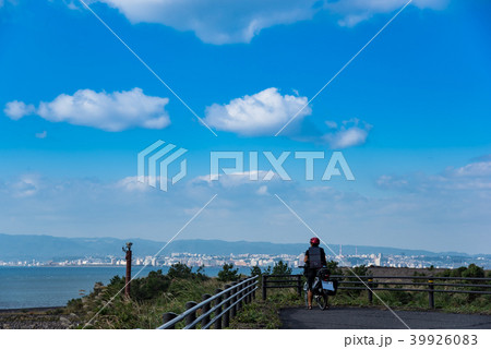 鹿児島　桜島　錦江湾ごしの鹿児島市を眺める自転車の青年 39926083