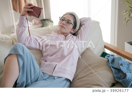ソファでダラダラする若い日本人女性の写真素材