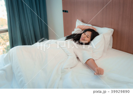Portrait of asian woman waking up in bedroom and s 39929890