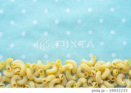 Macaroni rigati Beautiful decomposed pasta from the bottom on a green peas texture. Close-up view 39932235