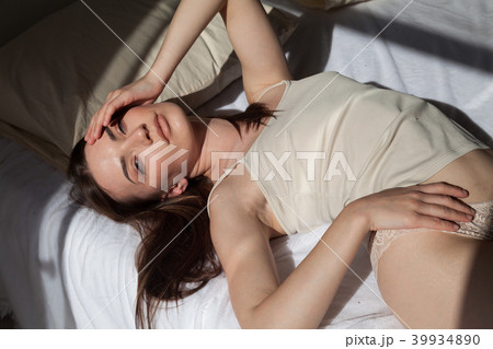 brunette in lingerie lay on a white bed in the bedroom brunette in lingerie lay on a white bed in the bedroom 39934890