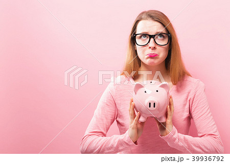 Young woman with a piggy bank 39936792
