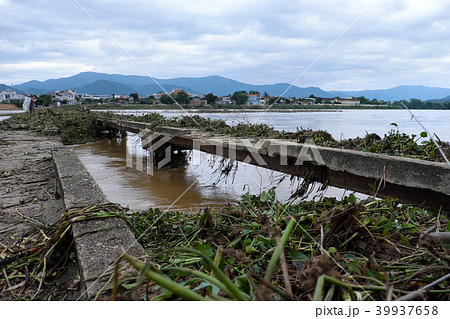 damaged bridge across flowing river damaged bridge across flowing river 39937658