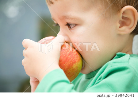 Little child is biting red apple and smile Little child is biting red apple and smile 39942041