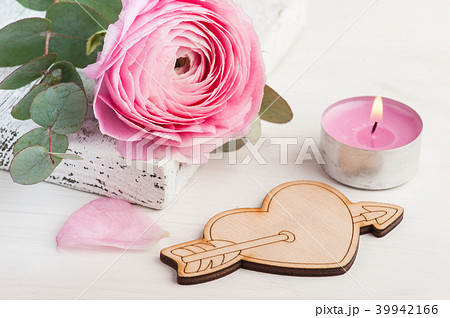 Pink buttercup flower with wooden heart Pink buttercup flower with wooden heart 39942166