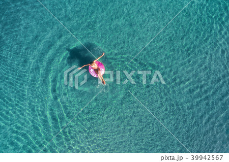 Aerial view of woman swimming on the swim ring Aerial view of woman swimming on the swim ring 39942567