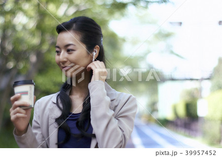 美しい新緑の中でハンズフリーで音楽を聴く女性 39957452