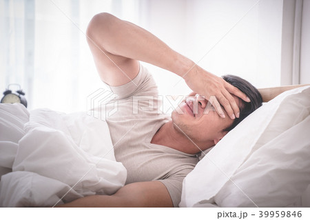 hangover man on bed woke up with headache 39959846