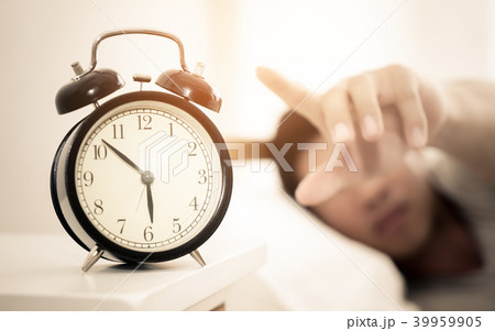 Man hand reaching out to alarm clock for snooze 39959905