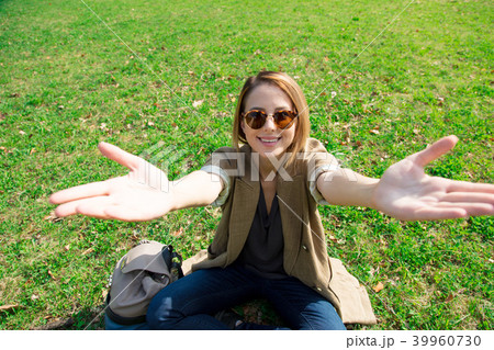 girl sitting on green grass in a park girl sitting on green grass in a park 39960730