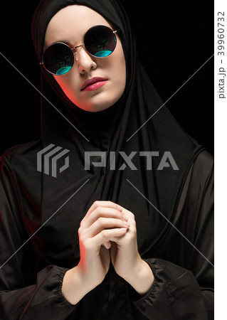 Portrait of beautiful stylish young muslim woman wearing black hijab and sunglasses as modern Portrait of beautiful stylish young muslim woman wearing black hijab and sunglasses as modern 39960732