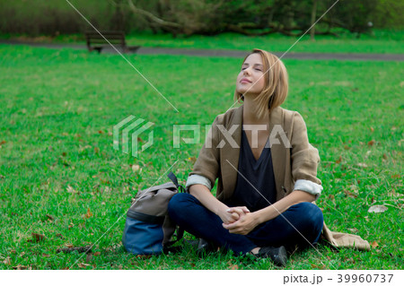 girl sitting on green grass in a park girl sitting on green grass in a park 39960737
