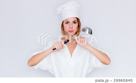 woman in cook uniform holding kitchenware 39960840