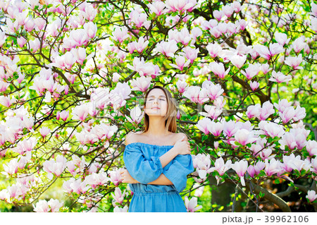 girl in blossom magnolia garden. 39962106