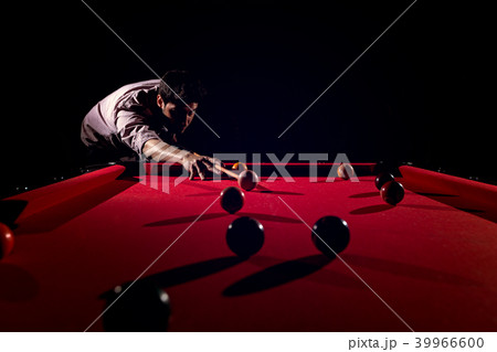A man with a beard plays a big billiard. 39966600