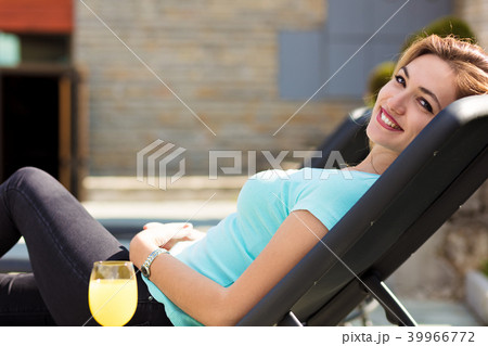 woman relaxing on lounger in the garden woman relaxing on lounger in the garden 39966772