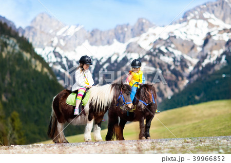 Kids riding pony. Child on horse in Alps mountains 39966852