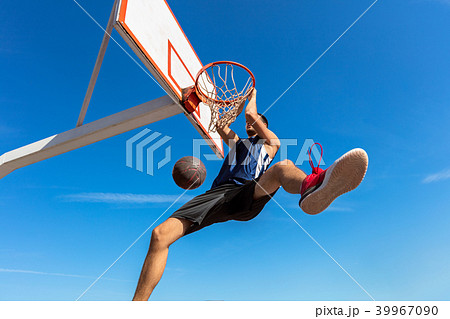 Slam Dunk. Side view of young basketball player making slam dunk 39967090