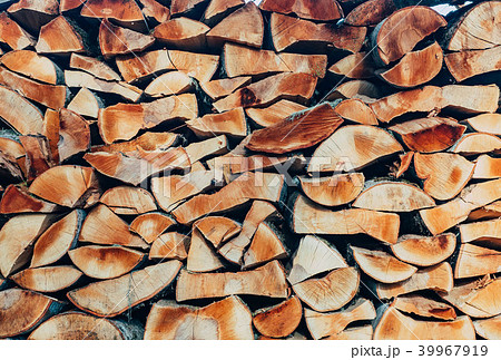 The chopped wood is packed in a woodpile. Firewood stacked on top of each other in rows. Wood The chopped wood is packed in a woodpile. Firewood stacked on top of each other in rows. Wood 39967919