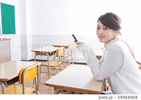 教室で携帯電話を使う学生 39968968