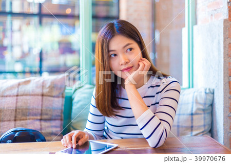 Happy young attractive asian woman in coffee shop 39970676