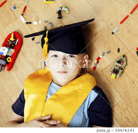 little cute preschooler boy among toys at home in graduate hat s 39976241