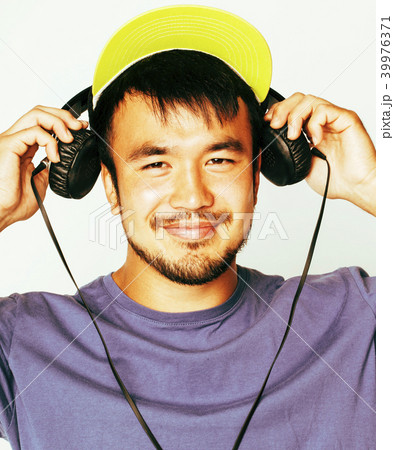 young asian man in hat and headphones listening music on white b young asian man in hat and headphones listening music on white b 39976371