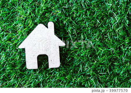 Small model house on green grass background 39977570