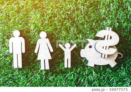 Wooden family and piggy bank on green grass  39977573