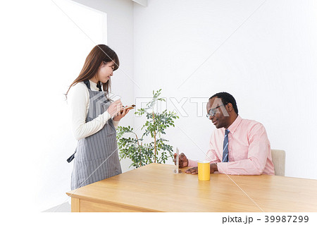 外国人に接客をするカフェスタッフの写真素材