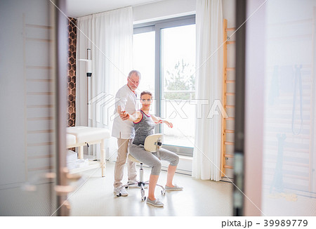 Senior male physiotherapist working with a female patient. 39989779