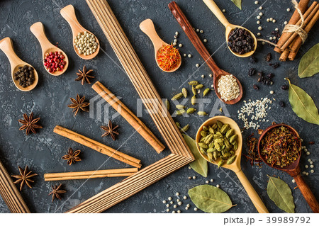 Various spices in wooden spoons on dark table Various spices in wooden spoons on dark table 39989792