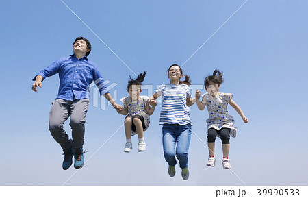 空を飛ぶ4人家族の写真素材