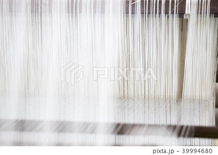 Closed up of loom with white thread background Closed up of loom with white thread background 39994680