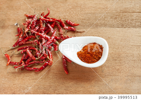 Cayenne pepper in white dish and dried chilli Cayenne pepper in white dish and dried chilli 39995513