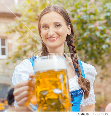 Woman wearing Dirndl drinking beer  39998049