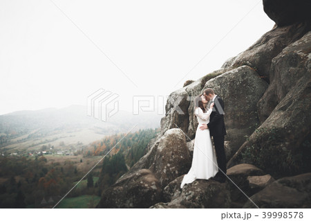 Wedding couple in love kissing and hugging near rocks on beautiful landscape Wedding couple in love kissing and hugging near rocks on beautiful landscape 39998578