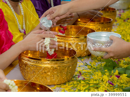 Young people is pouring water to older people 39999551