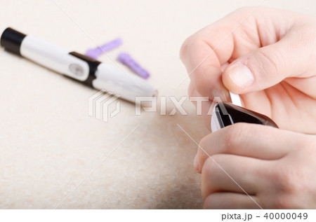 Man inserting blood test strip in glucometer  40000049
