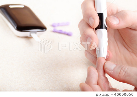 Man Pierce his fingertip before doing blood test 40000050