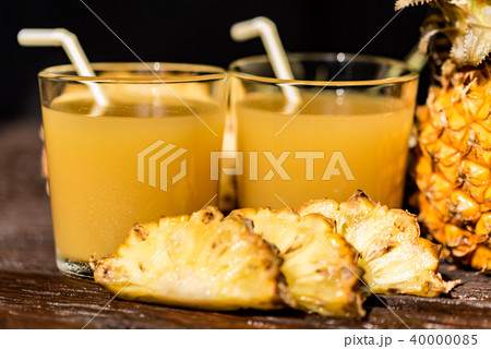Pineapple juice and slice placed on a wooden table Pineapple juice and slice placed on a wooden table 40000085