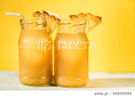 Pineapple juice and slice placed on a wooden table Pineapple juice and slice placed on a wooden table 40000099