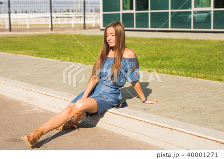 Girl sitting on street in summer day 40001271