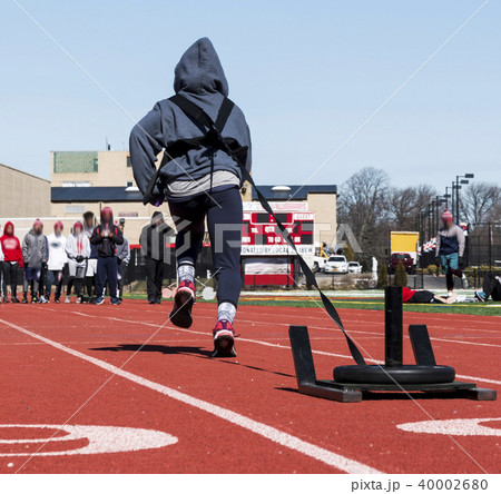 Athlete pulling a sled with weights on a track 40002680
