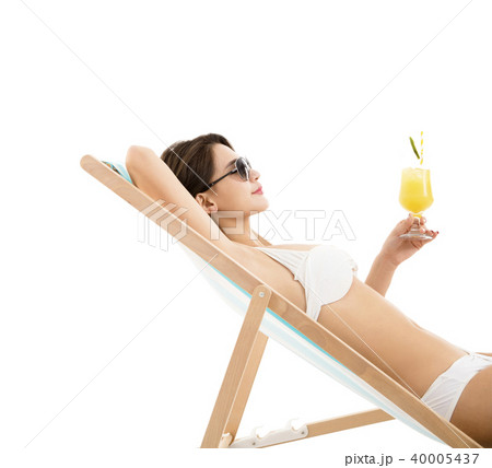 young woman in lounge chair with cocktail young woman in lounge chair with cocktail 40005437