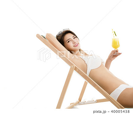 young woman in lounge chair with cocktail young woman in lounge chair with cocktail 40005438