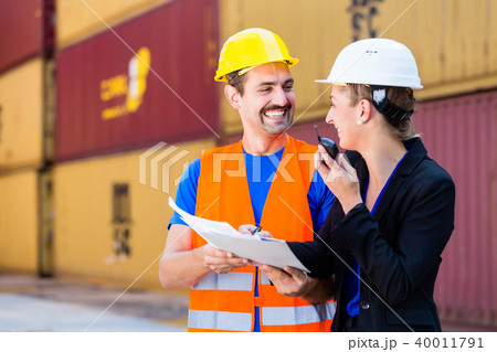 workers in logistics company discussing documents workers in logistics company discussing documents 40011791